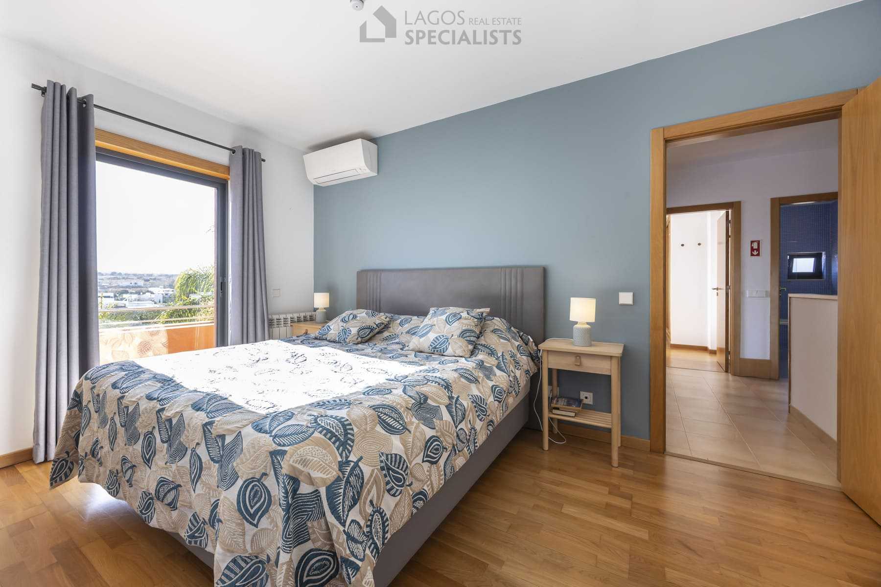 Bright bedroom with balcony and soft blue wall in modern Lagos villa