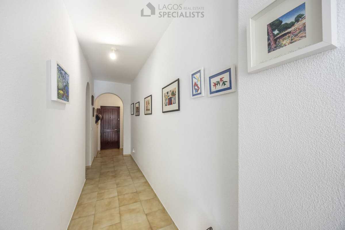 Long hallway with framed artwork and archways leading to the entrance in Iberlagos apartment, Lagos