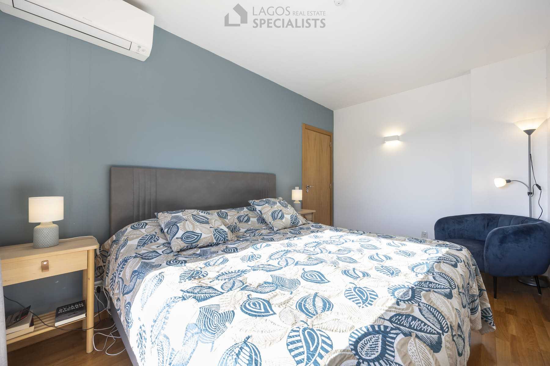Peaceful bedroom with soft blue tones and patterned bedding in Algarve home