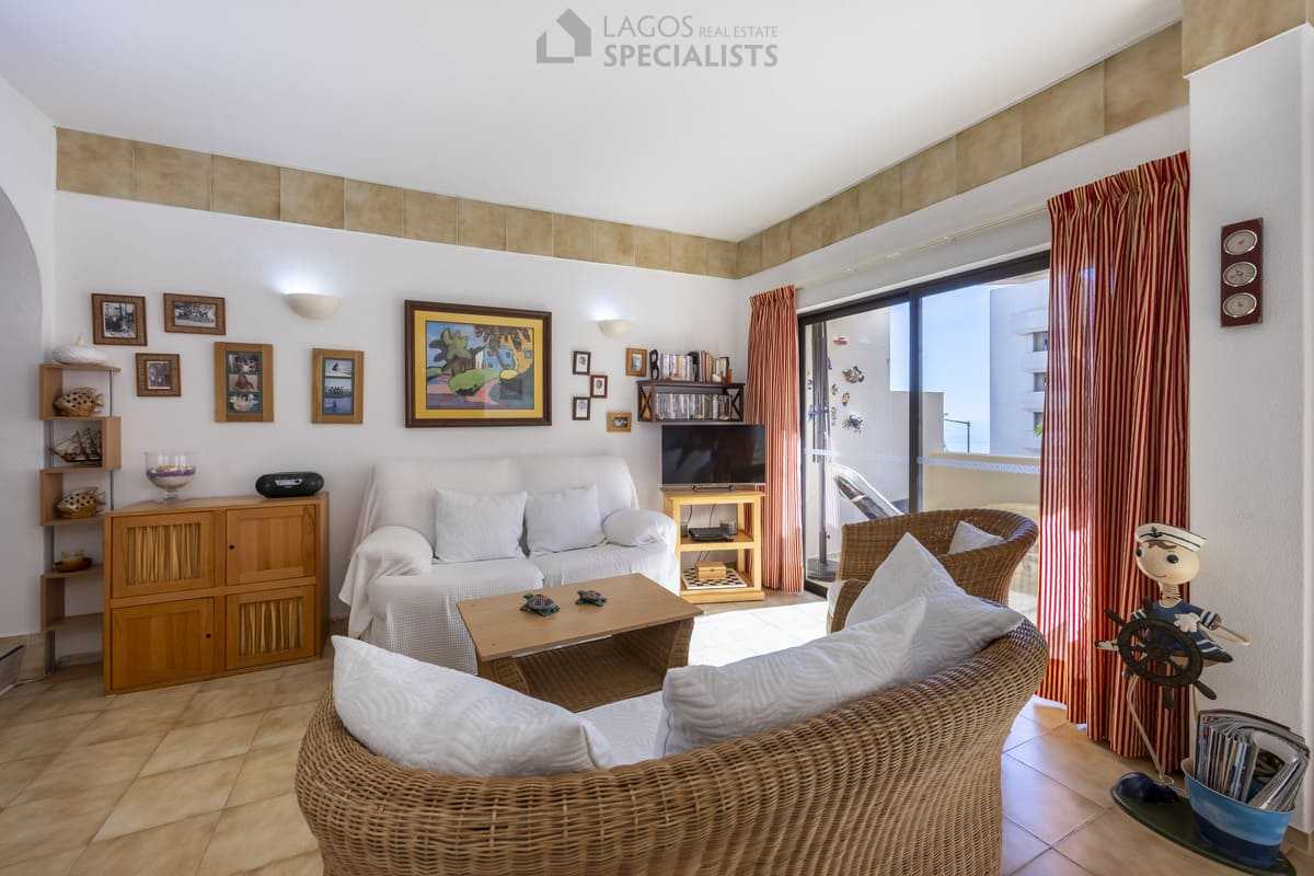 Cosy living room with rattan sofas, TV unit and terrace doors offering a sea glimpse at Iberlagos, Lagos