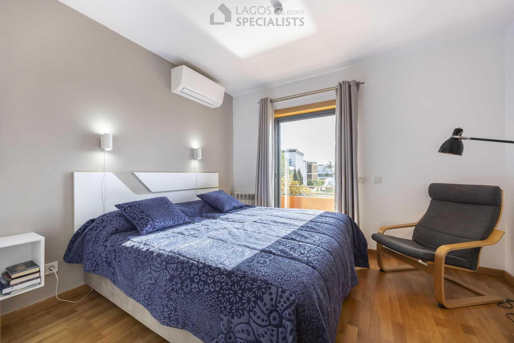Comfortable bedroom with armchair and mirrored wardrobe, Lagos home