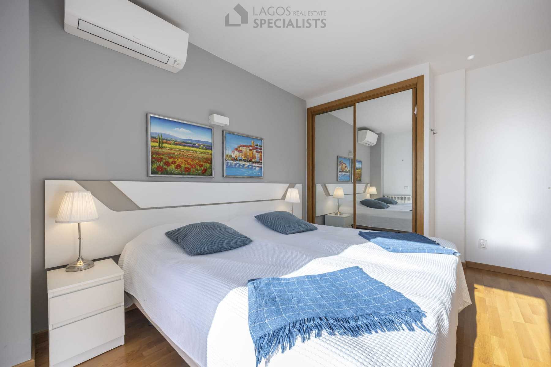 Bright bedroom with two lamps, white bedding, and framed art, Lagos home