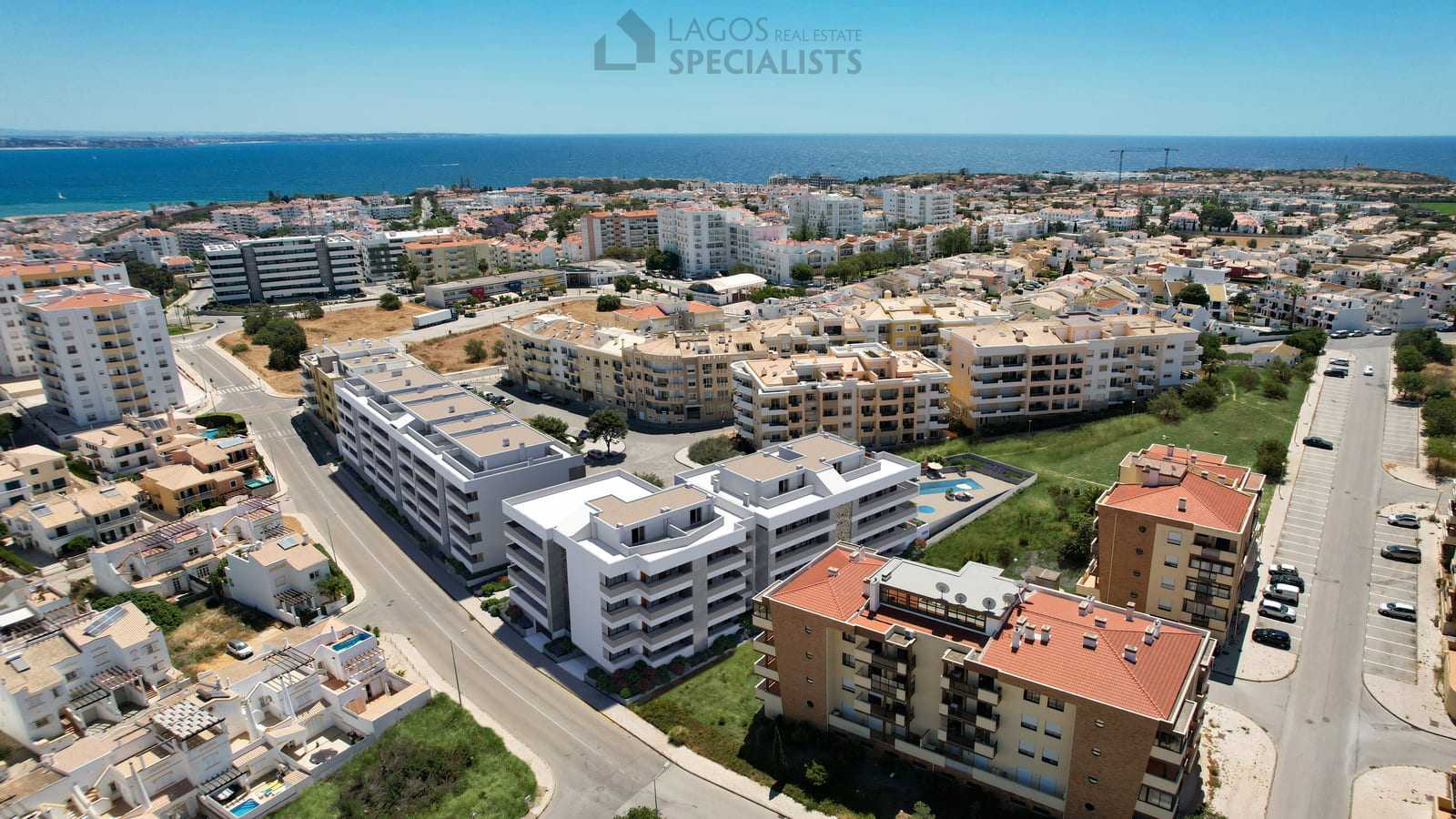 Drone photo of contemporary apartments in Lagos showing modern design, communal pool, and close distance to the sea.