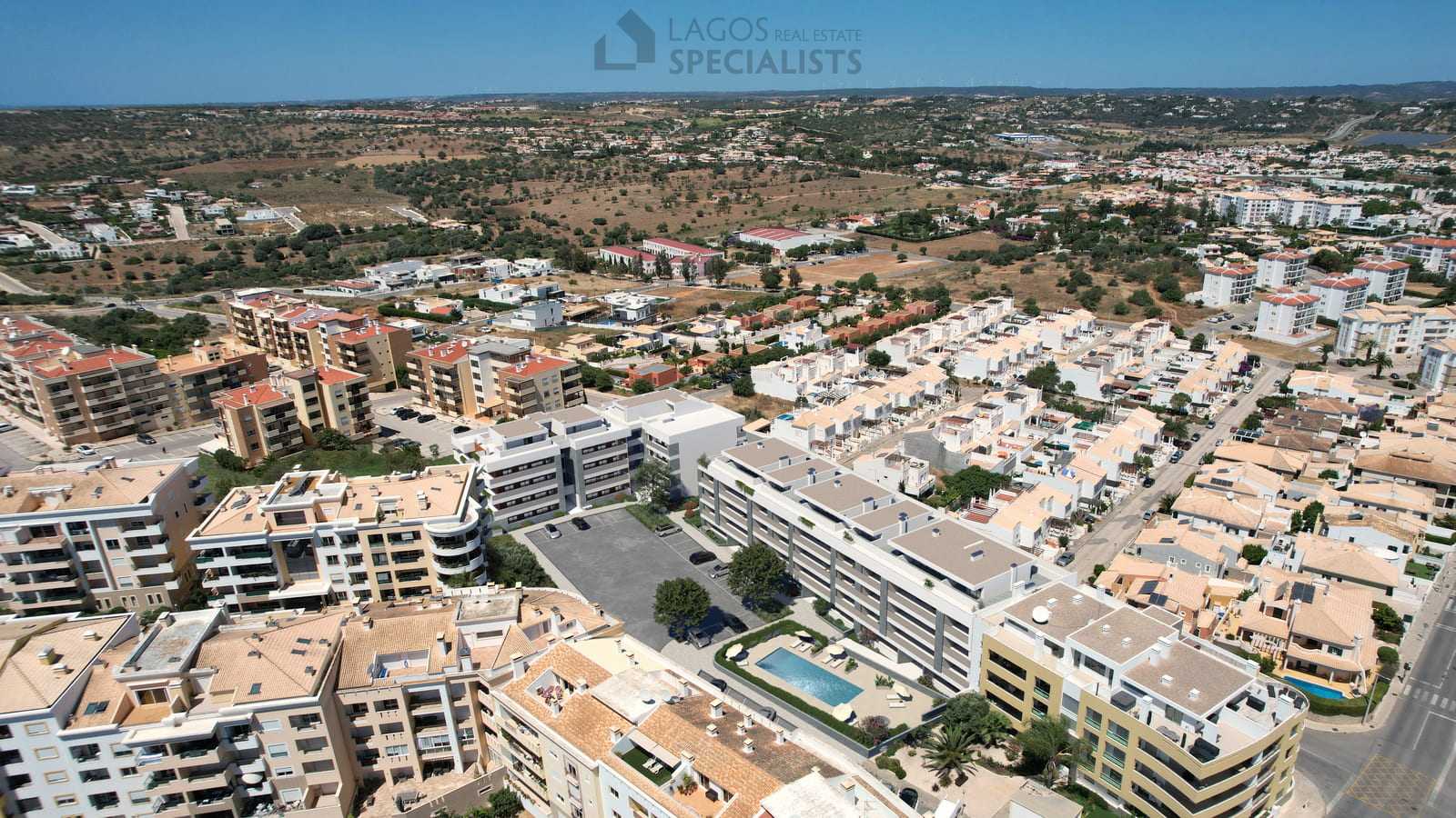 Bird’s-eye view of luxury new-build apartments in Lagos, Algarve, surrounded by calm residential streets and countryside.