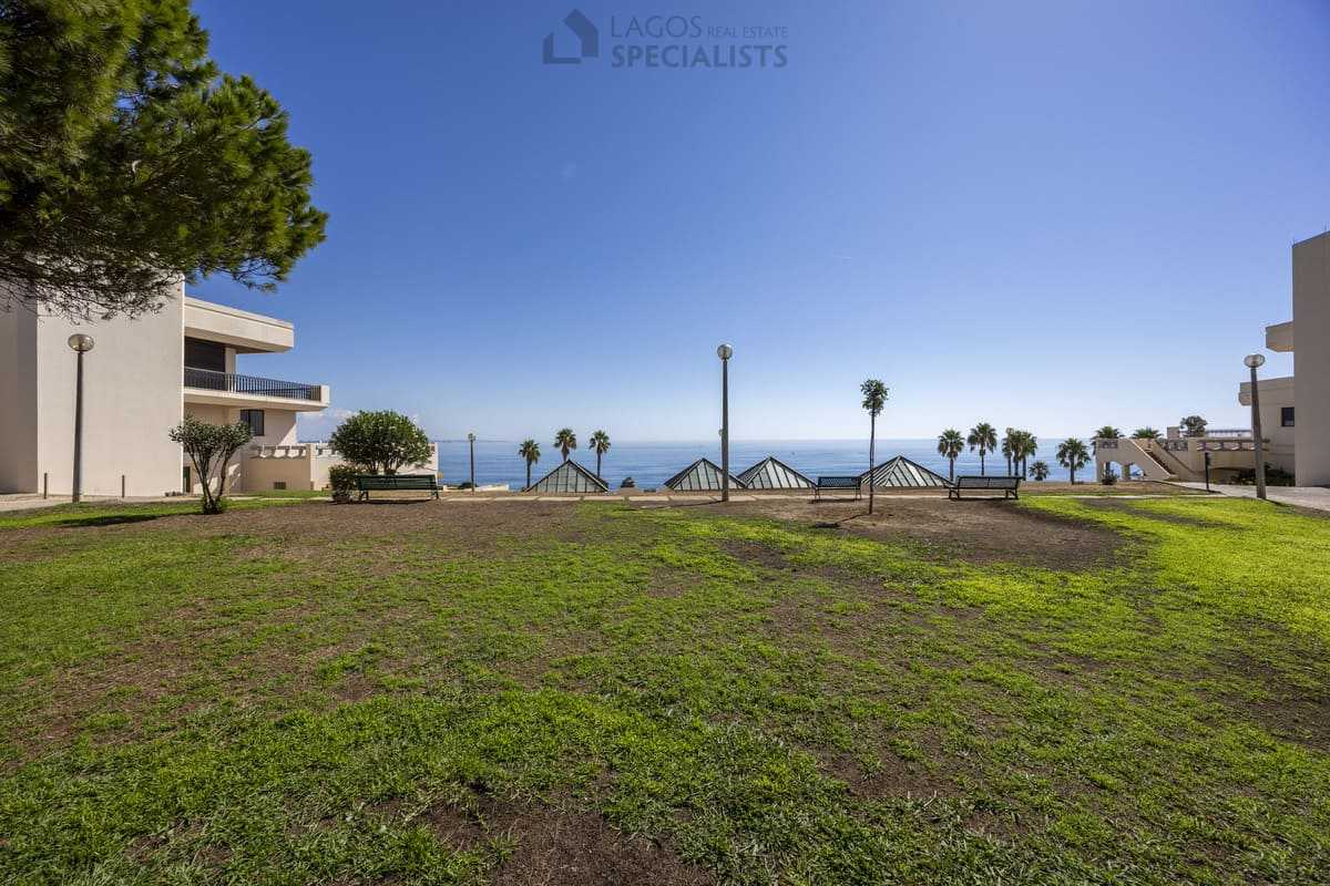 Communal gardens at Iberlagos with benches and sea views above Dona Ana Beach, Lagos Algarve