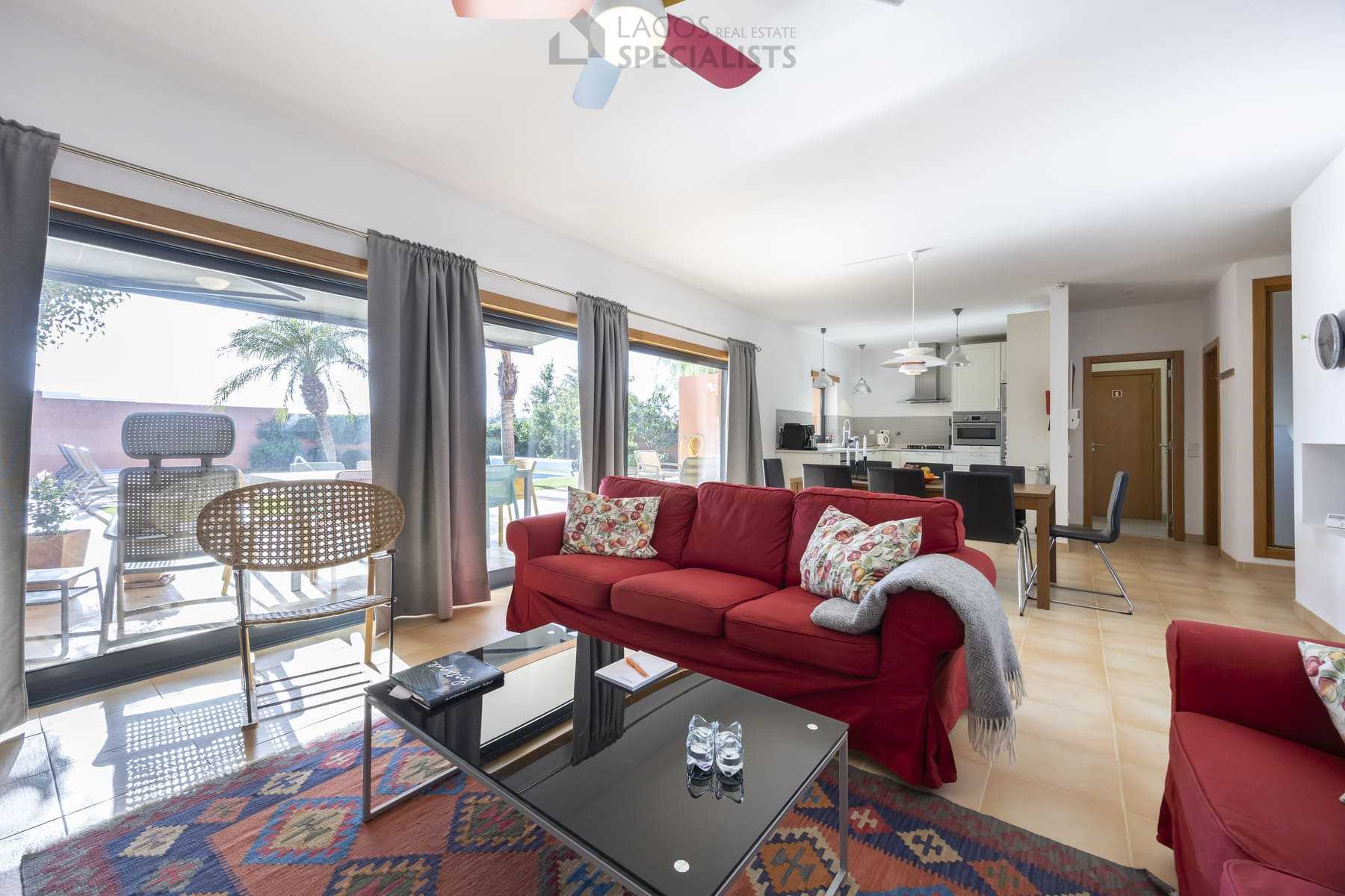 Open-plan living room with red sofas and garden view, Lagos property