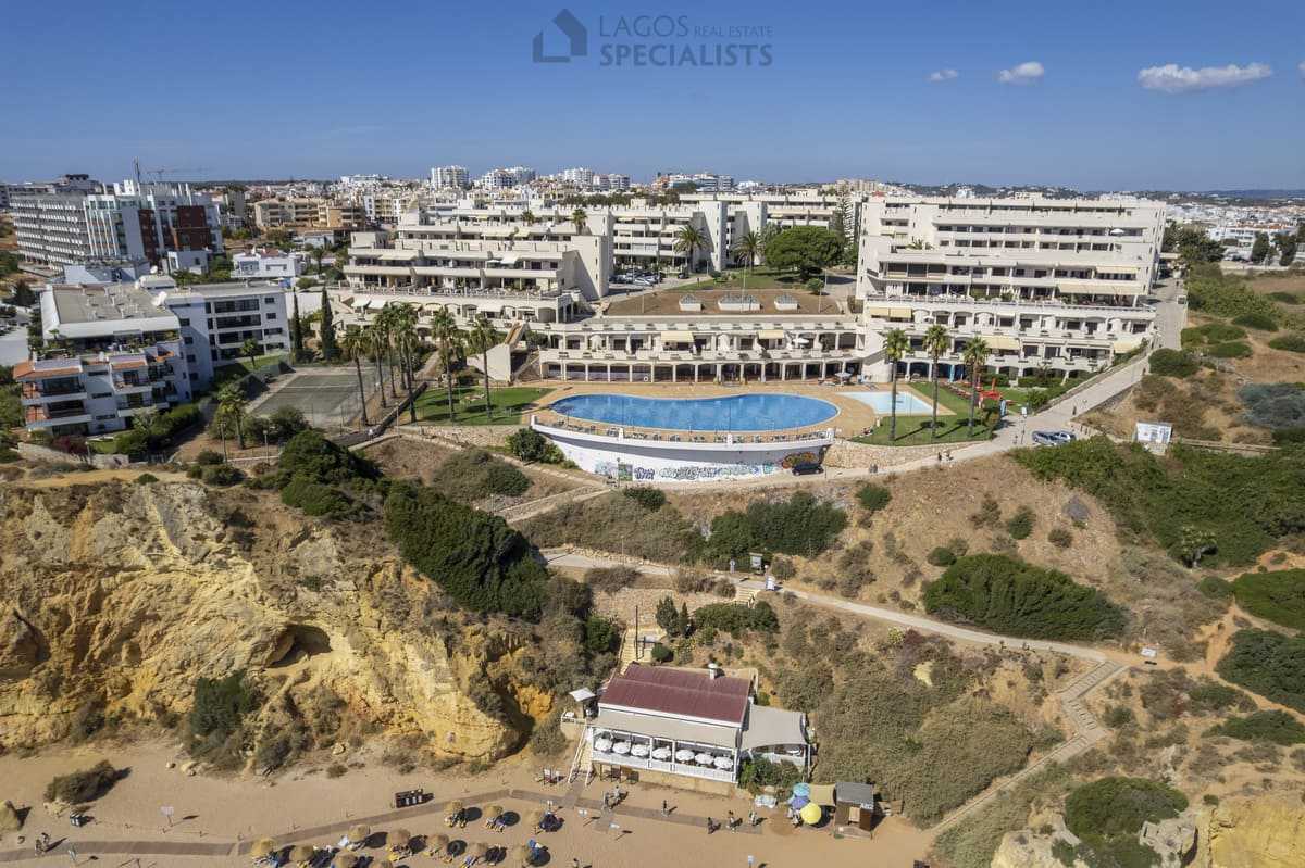 Aerial view of Iberlagos resort above Dona Ana Beach with cliff coastline and large sea-view pool, Lagos Algarve