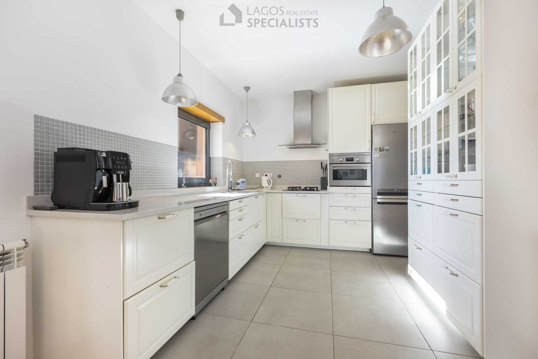 Bright modern kitchen with white cabinets and stainless-steel appliances