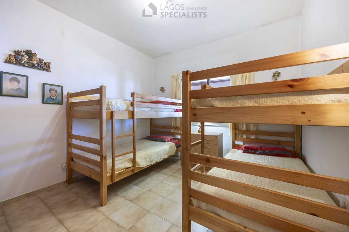 Family-friendly second bedroom with two wooden bunk beds and window in an Iberlagos apartment near Dona Ana Beach