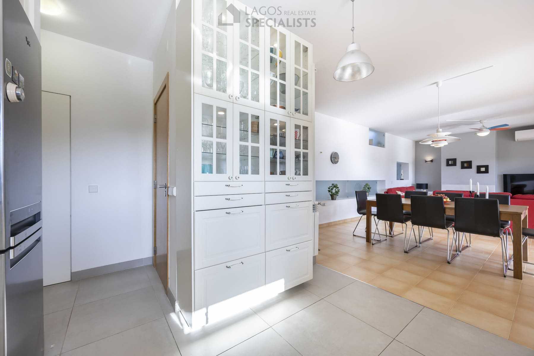 Open kitchen entrance with dining area and glass cabinets, Lagos villa