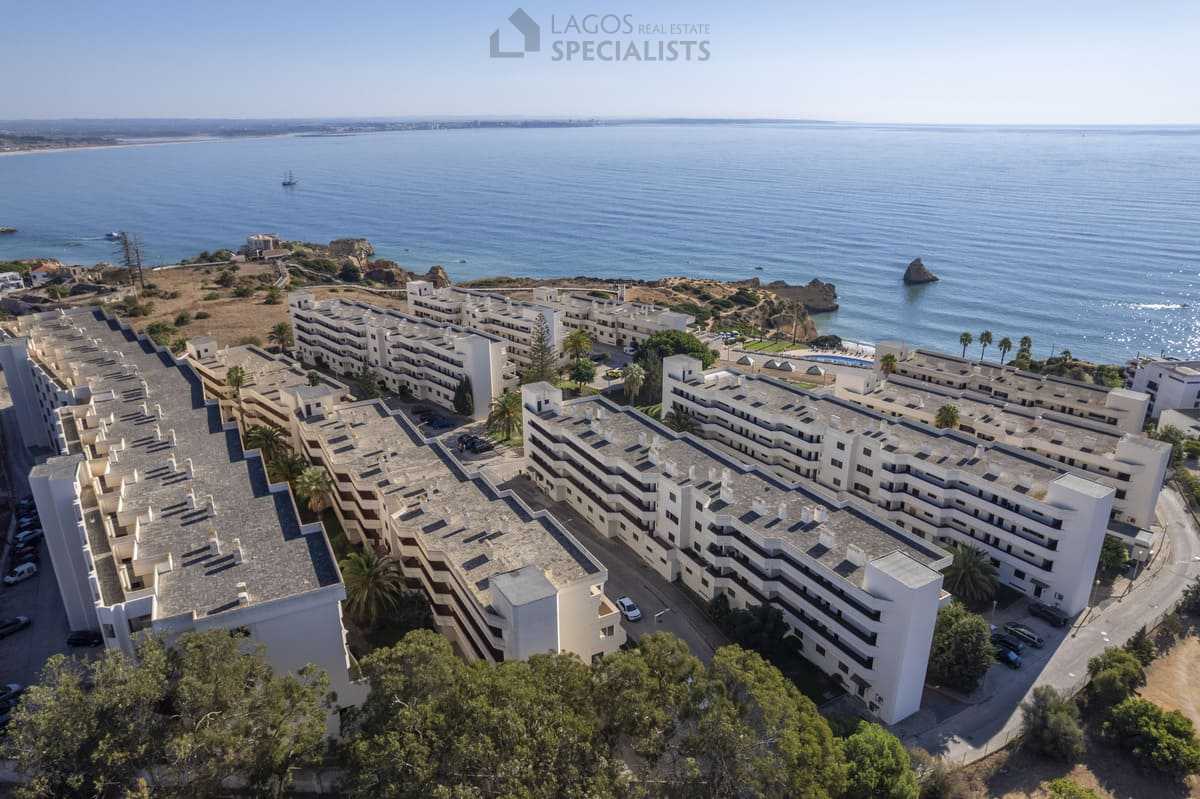 High-angle aerial of Iberlagos by the Dona Ana cliffs with boardwalks and Algarve coastline
