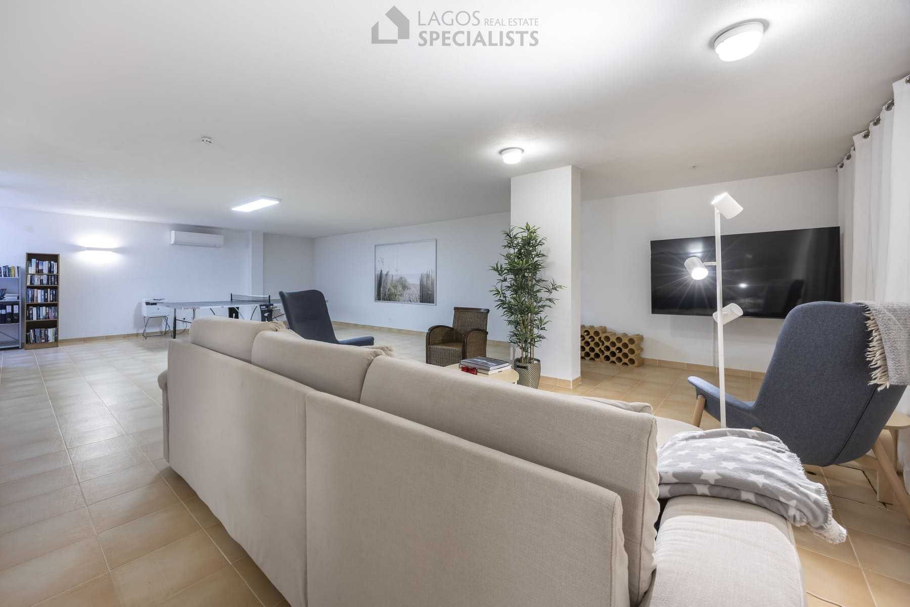 Basement sitting area with blue chairs and modern decor, Algarve home