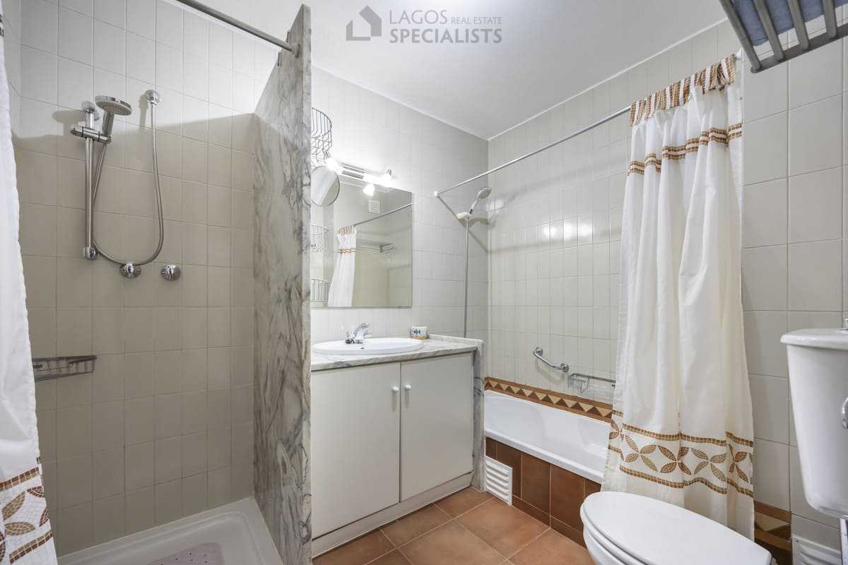 Bright tiled bathroom with vanity, bath and shower in an Iberlagos apartment in Lagos, Algarve
