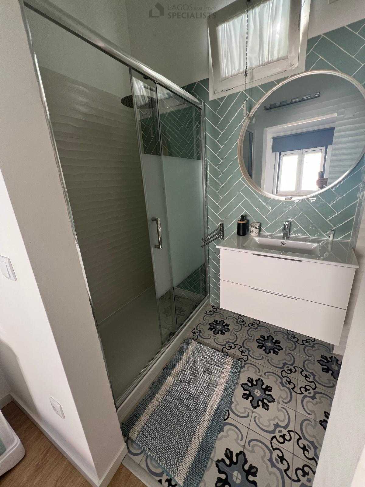 Modern bathroom with walk-in shower and patterned tiles – renovated house in Lagos