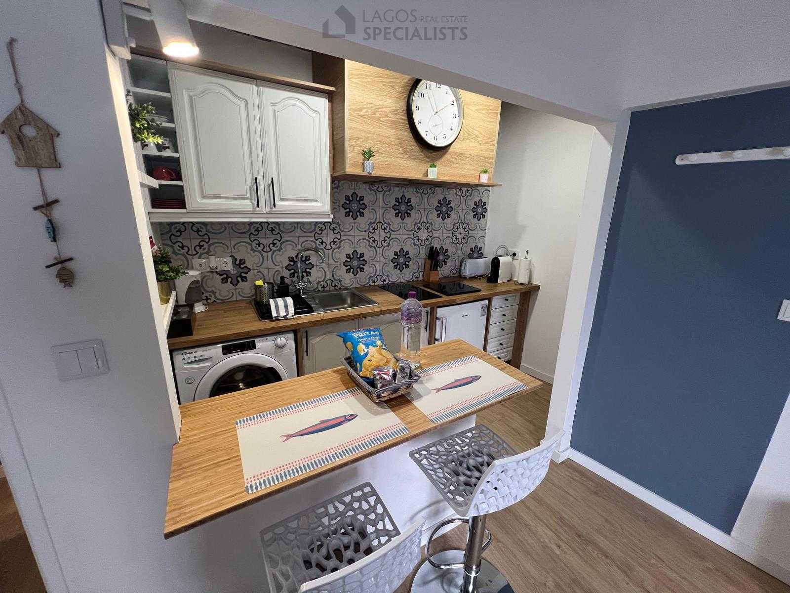 Compact kitchen with breakfast bar and decorative tiles – renovated 1-bed house in Lagos