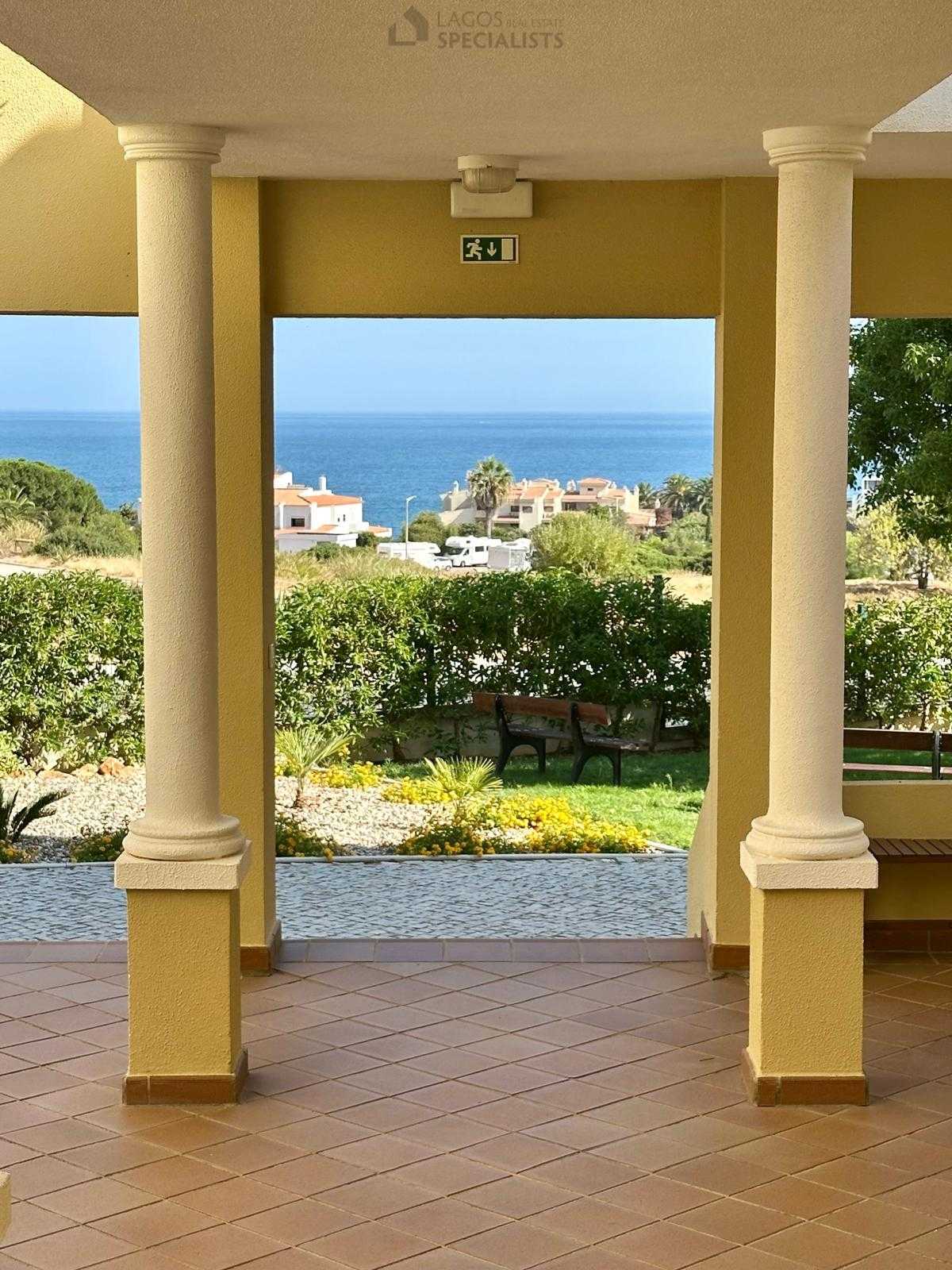 Garden walkway with sea view framed by columns at condominium in Porches Algarve