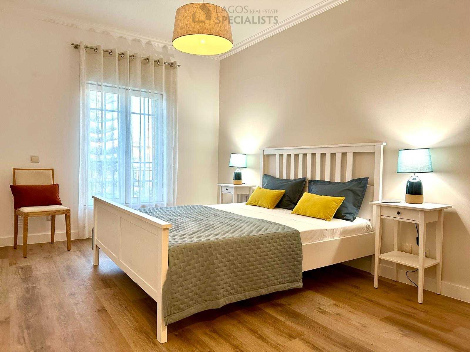 Master bedroom with white bed frame, matching nightstands, and soft décor