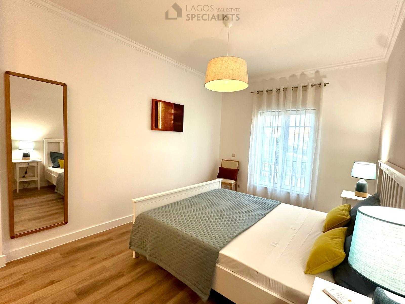 Master bedroom with white bed frame, matching nightstands, and soft décor