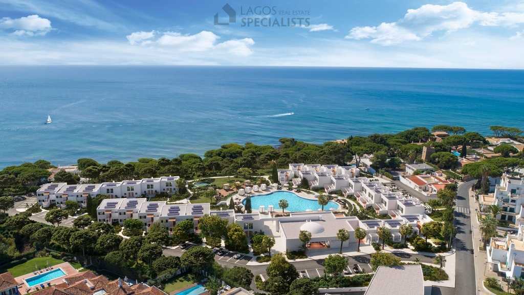 Aerial view of ocean front resort in the Algarve with pool, pine trees, and panoramic sea views