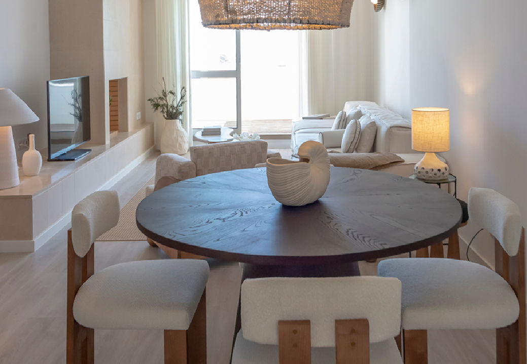 Open-plan living and dining area with contemporary coastal décor and natural textures in Algarve apartment