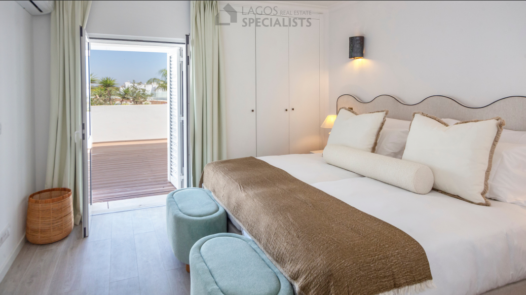 Bright master bedroom with direct terrace access, soft neutral tones, and natural light in Algarve apartment