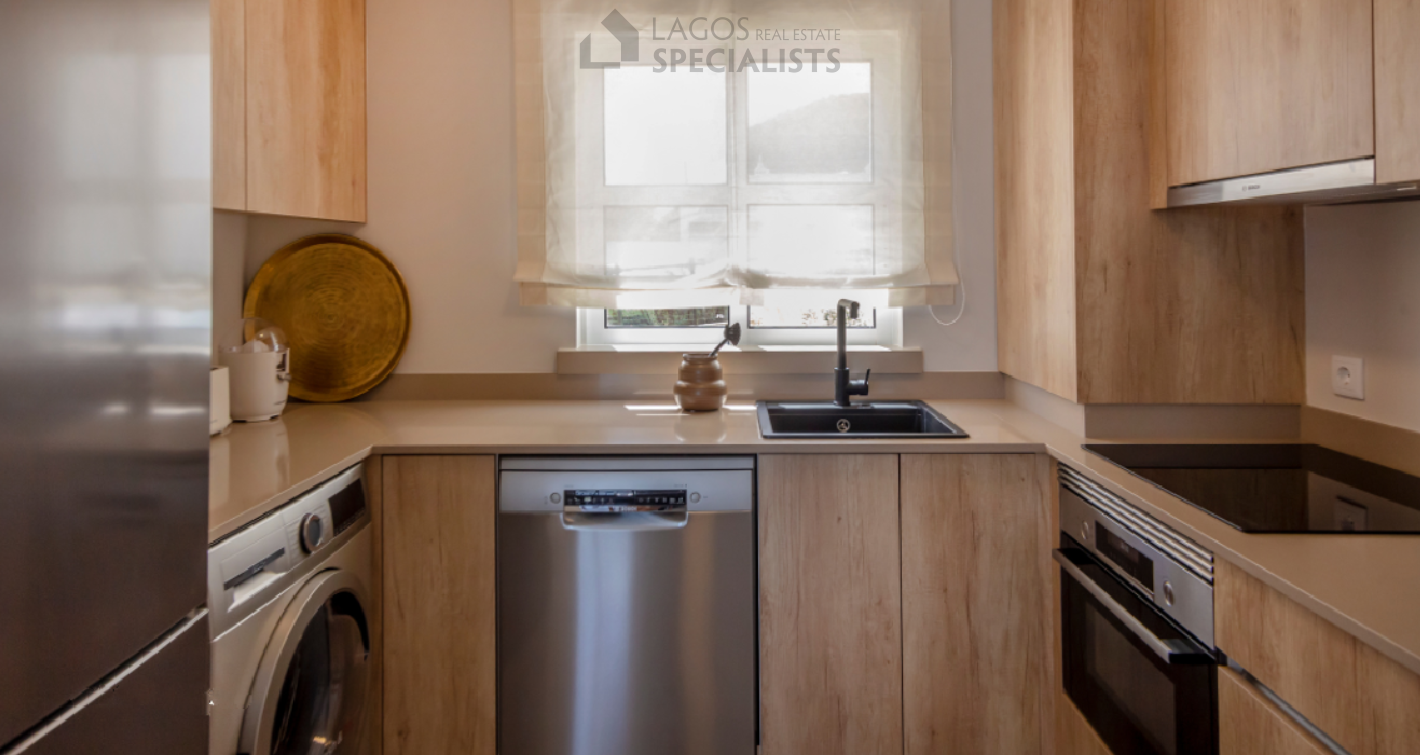 Fully equipped modern kitchen with integrated appliances in Algarve apartment