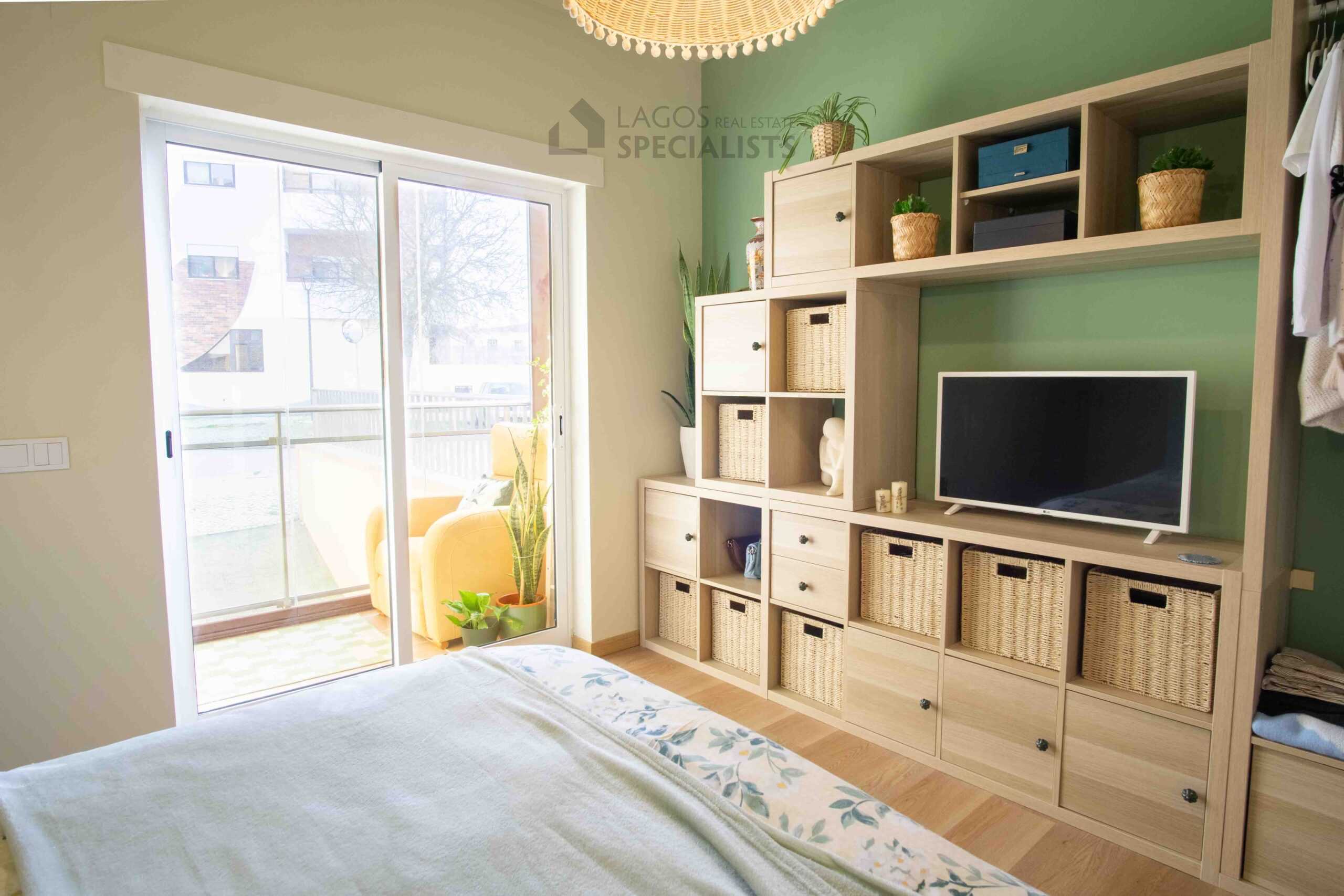 Bright bedroom with green feature wall, double bed and balcony access in modern Lagos apartment