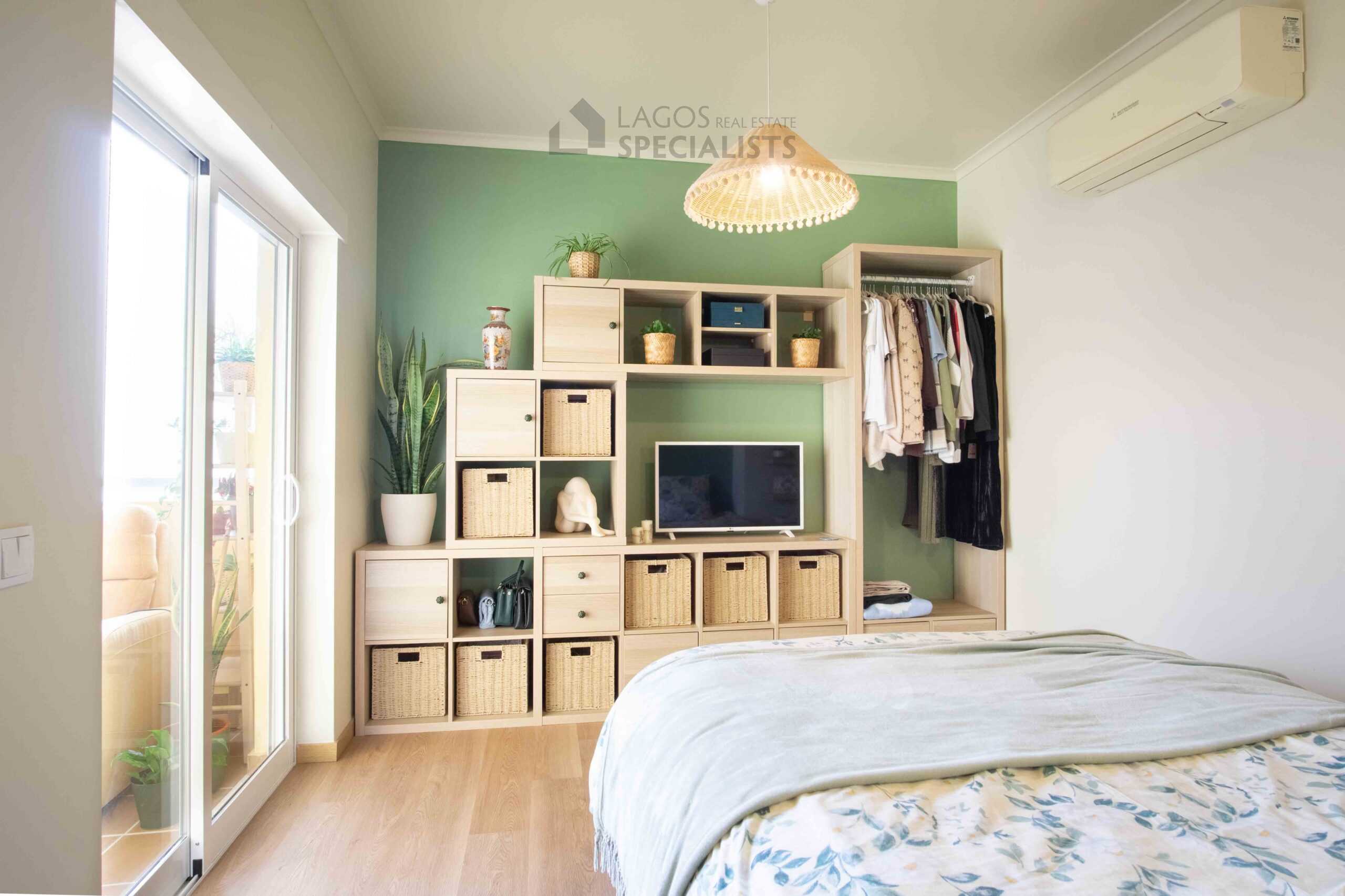 Bright bedroom with green feature wall, double bed and balcony access in modern Lagos apartment