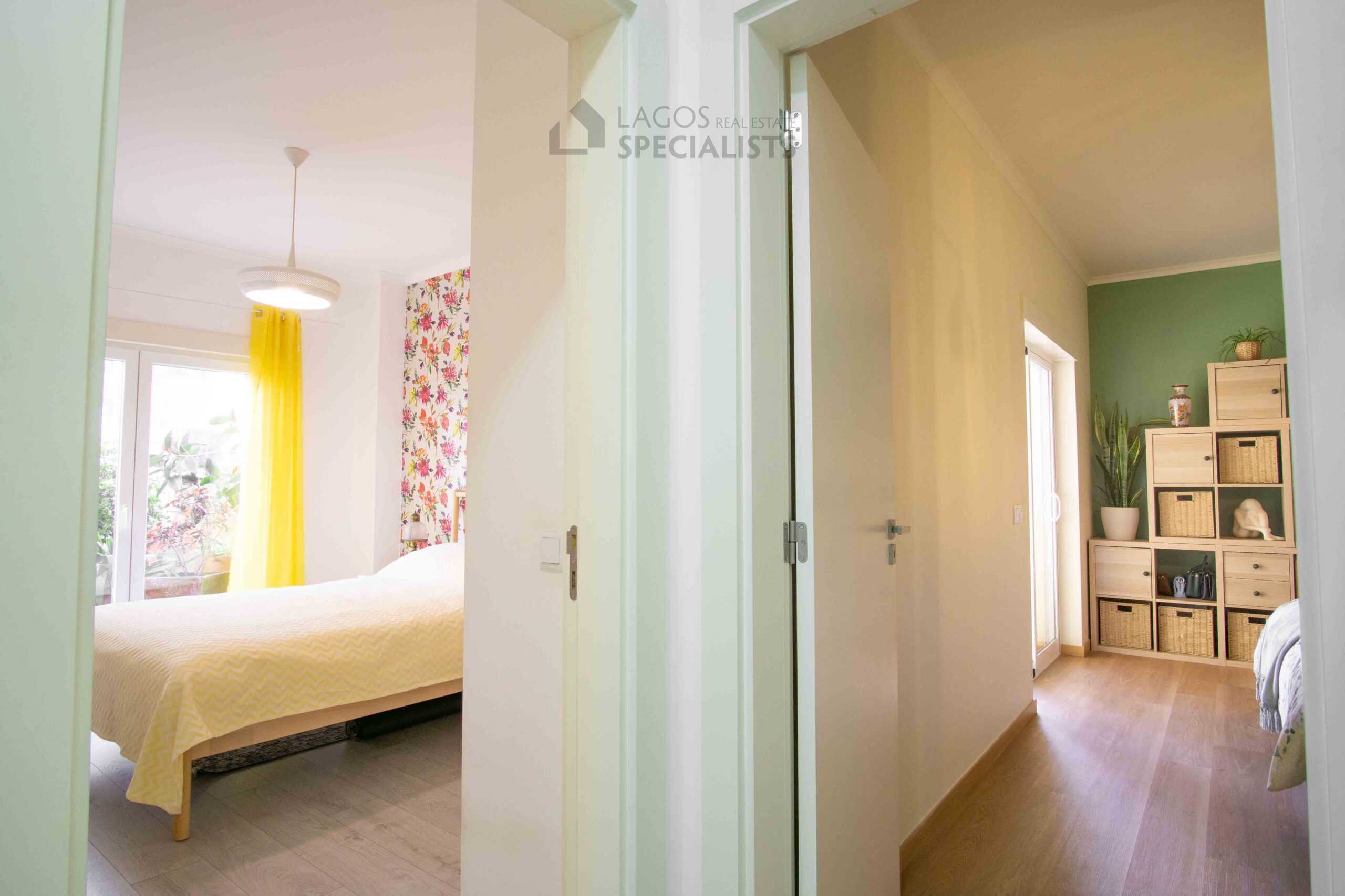 Clean and modern hallway connecting bedrooms and living areas in a spacious Lagos apartment with wood flooring and neutral tones
