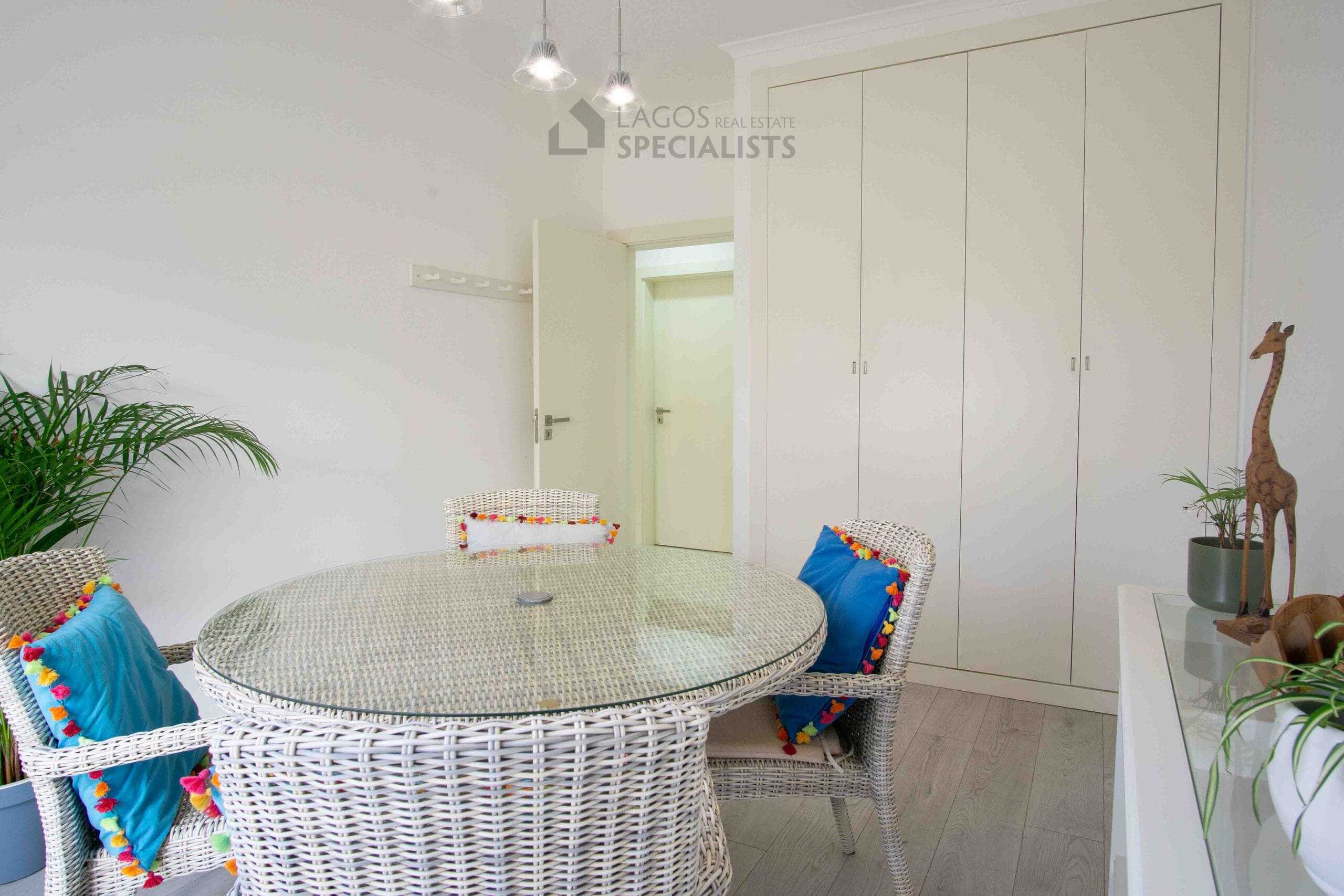 Dining area featuring built-in storage, neutral finishes, and contemporary lighting in a well-maintained Lagos apartment