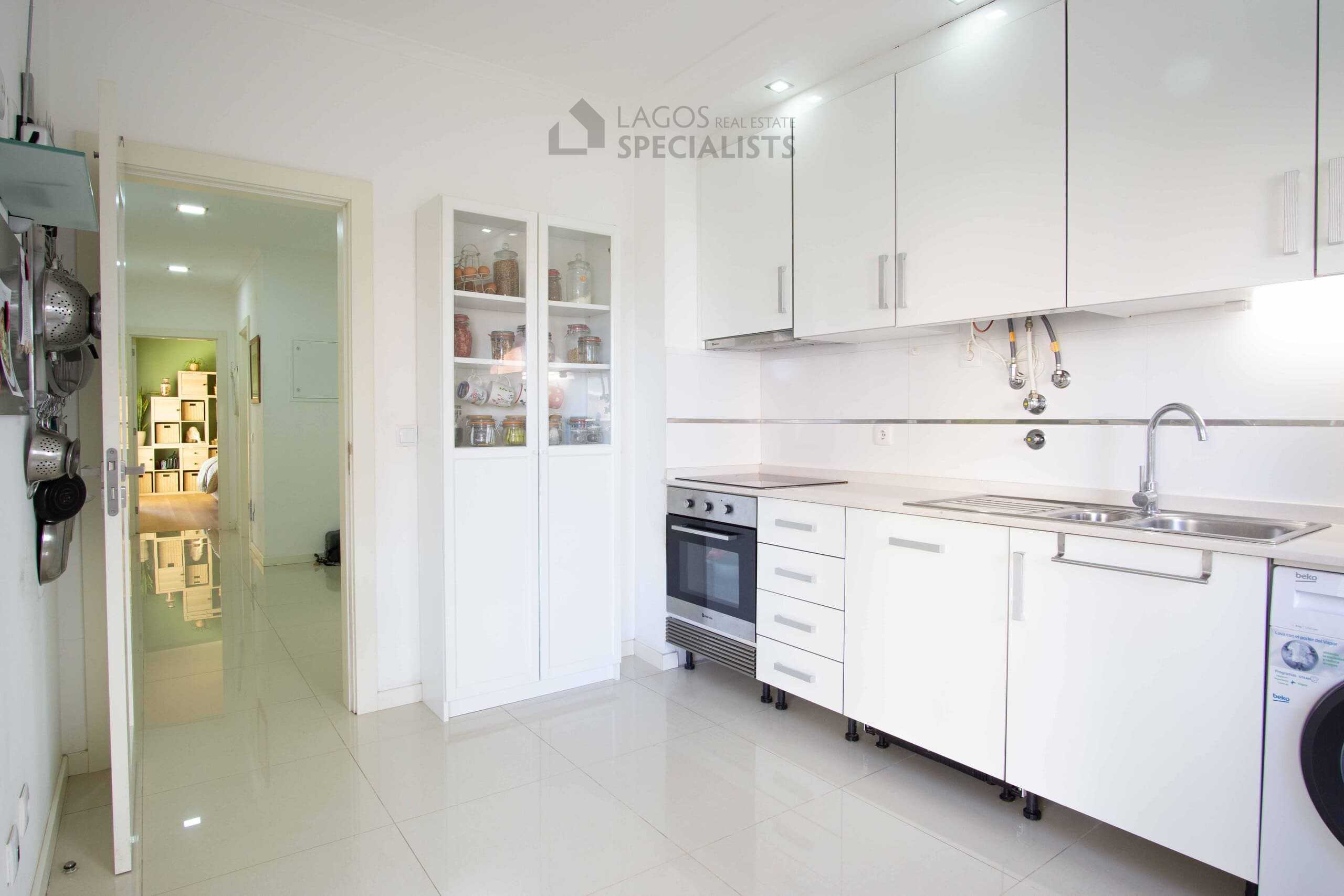 Modern kitchen with sleek white cabinets.
