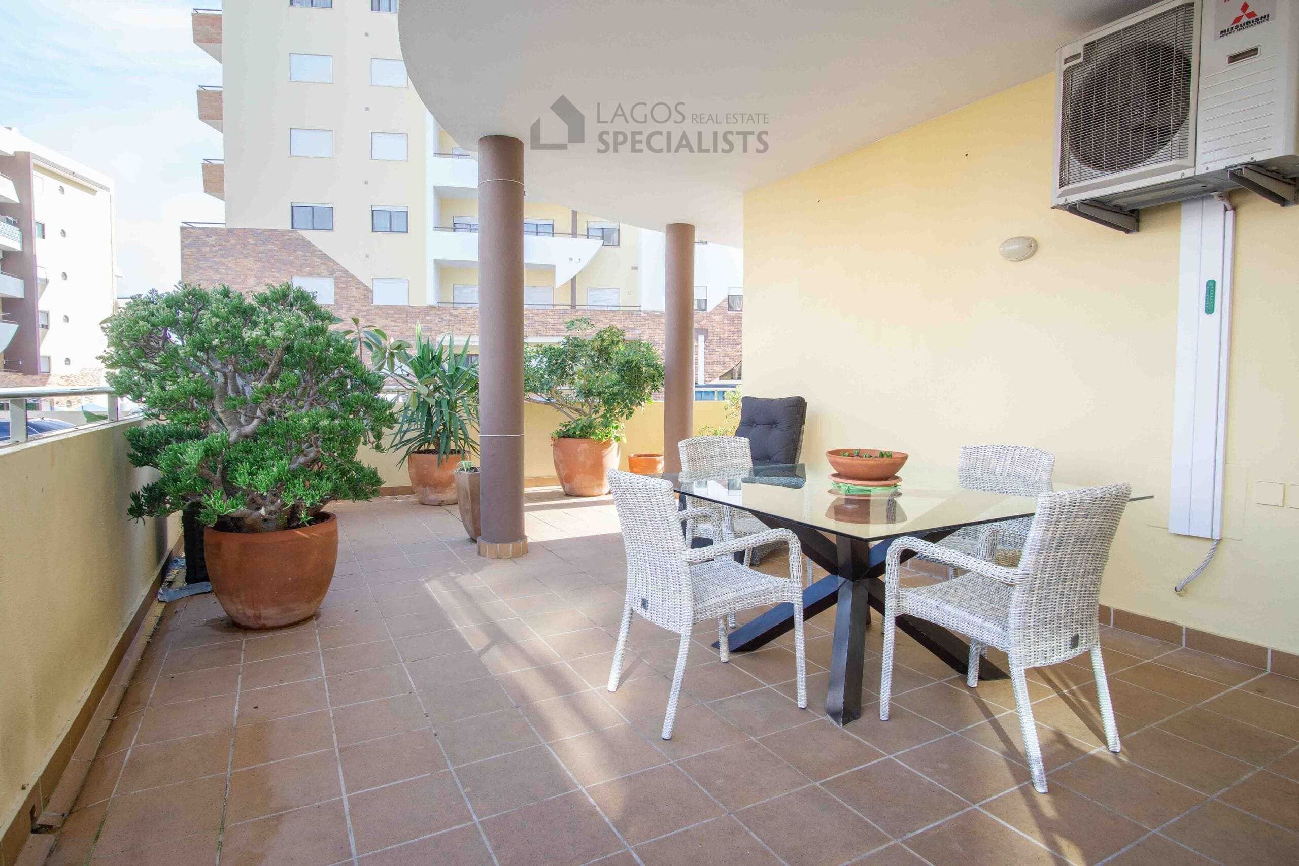 Spacious balcony with outdoor furniture.
