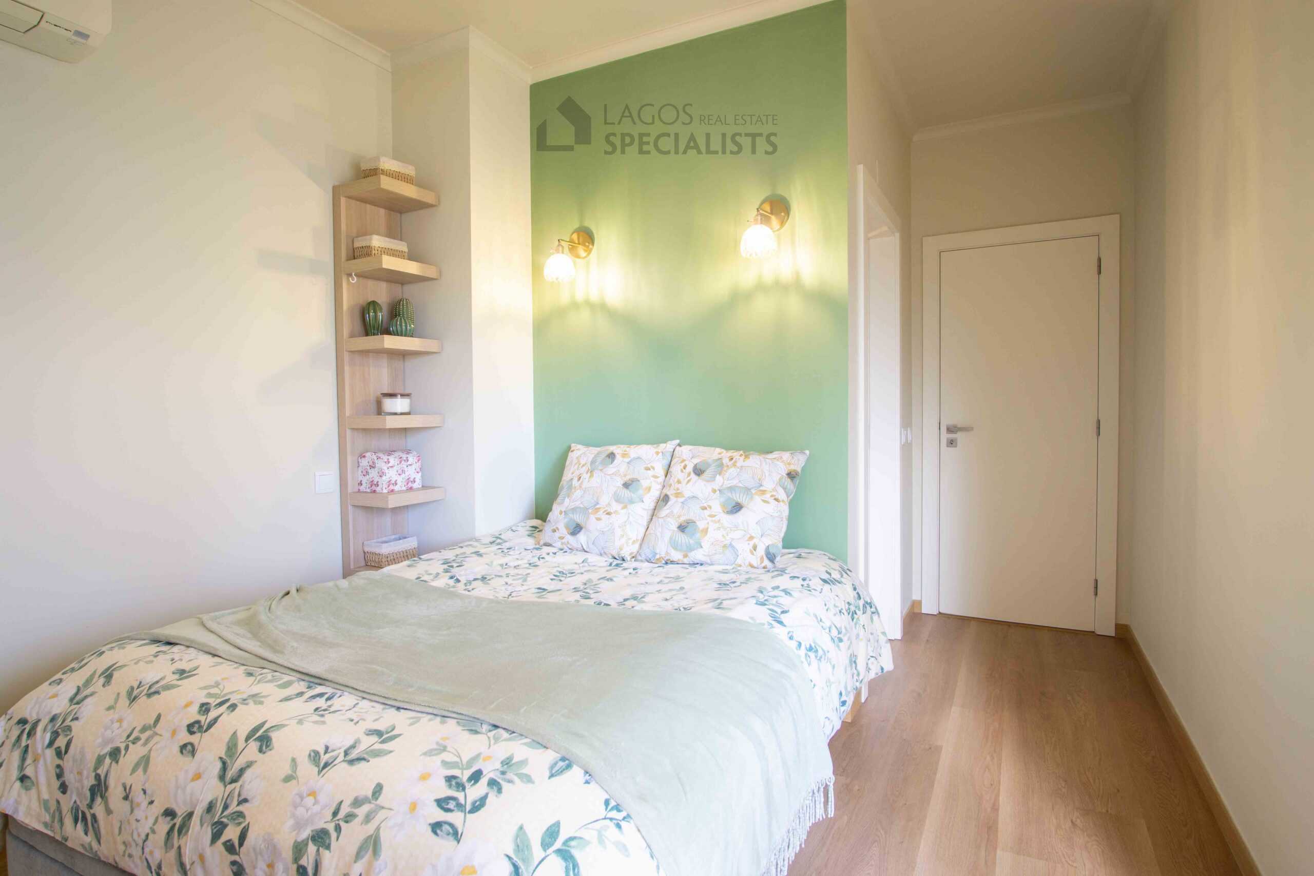 Bright bedroom with green feature wall, double bed and balcony access in modern Lagos apartment