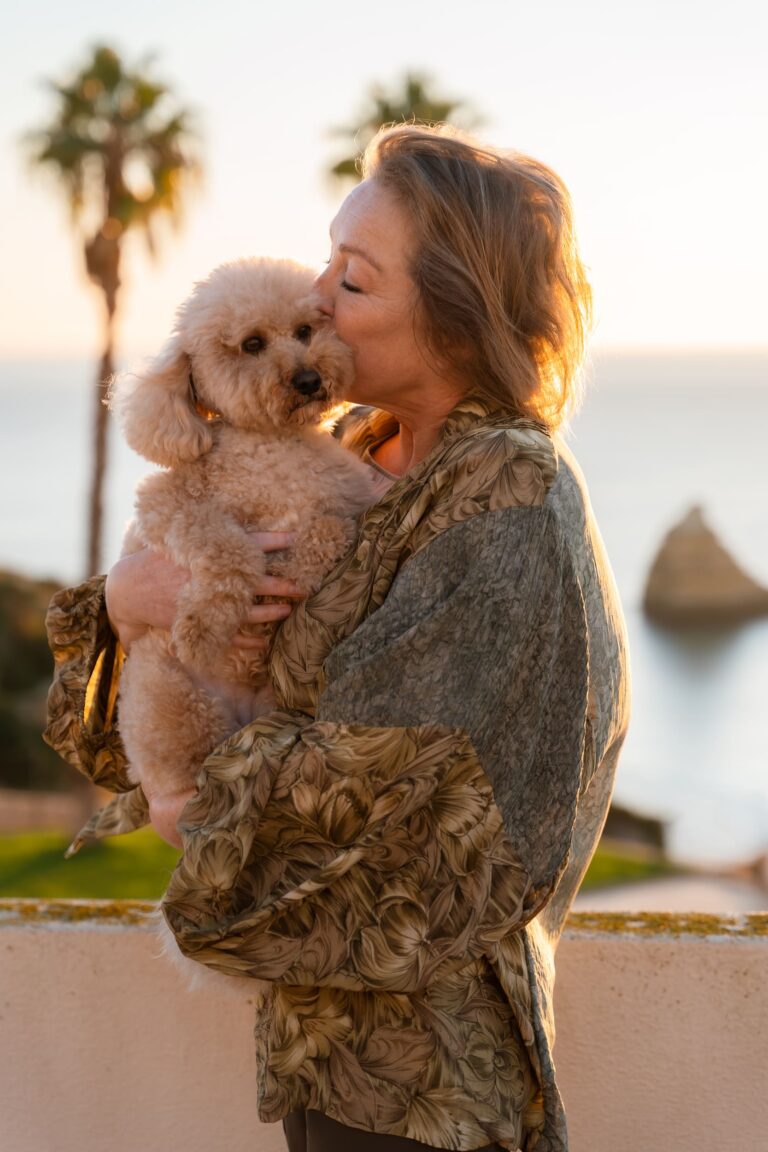 Natasha Hunt and dog Dolly on Algarve real estate tips with palm trees and coastal background